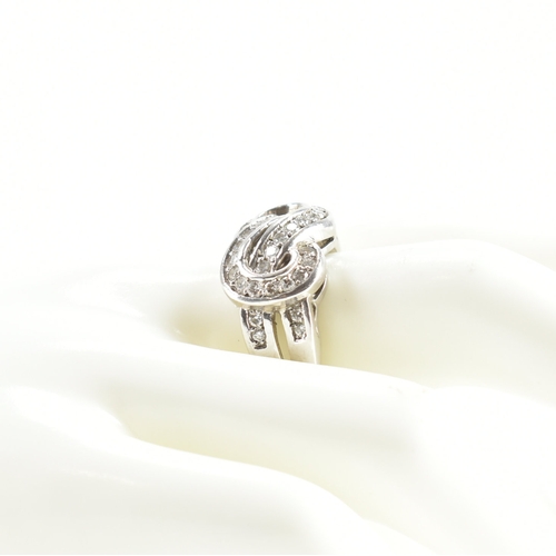 490 - A hallmarked 9ct white gold and diamond knot design ring. The ring being set throughout with round c... 