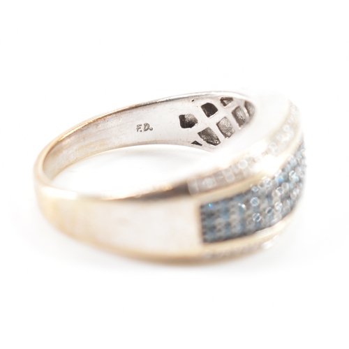 486 - A white gold blue and white diamond ring. The ring having a central band of blue stones flanked by w... 