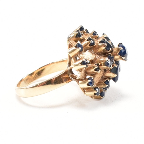 17a - A 1970s 18ct yellow gold and sapphire bombe cocktail ring. The ring having a round cut sapphire to t... 