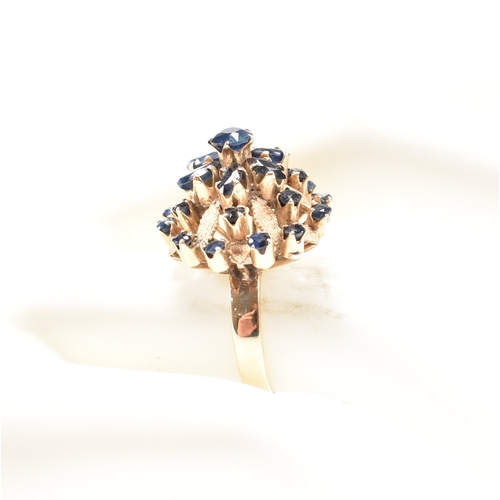 17a - A 1970s 18ct yellow gold and sapphire bombe cocktail ring. The ring having a round cut sapphire to t... 