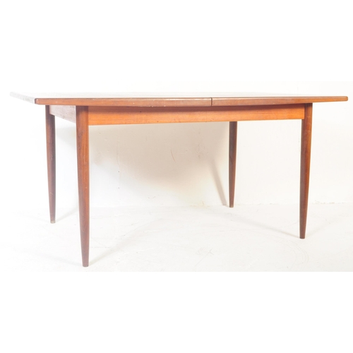 579 - A retro mid 20th century teak dining table. The table of rectangular form having rounded chamfered e... 