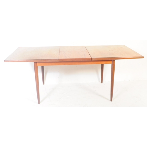 579 - A retro mid 20th century teak dining table. The table of rectangular form having rounded chamfered e... 