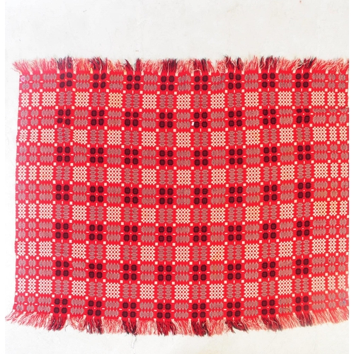 583 - A vintage 20th century Welsh blanket. Of rectangular form with geometric pattern squares, in red, wh... 