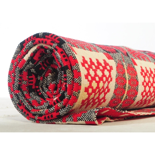 583 - A vintage 20th century Welsh blanket. Of rectangular form with geometric pattern squares, in red, wh... 