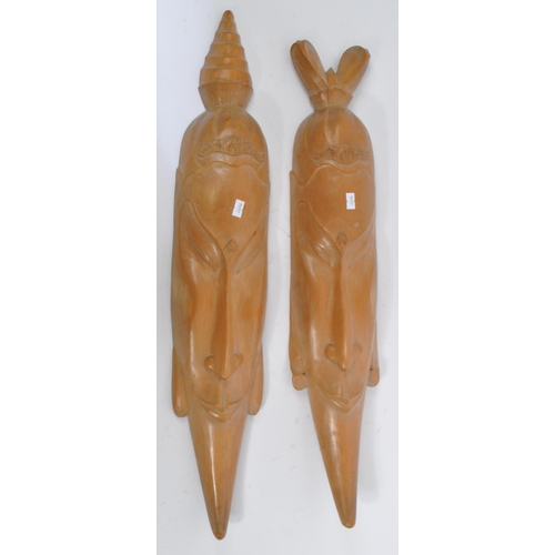618 - A pair of vintage 20th century ash carved African tribal wall hanging masks. With headdress attire t... 