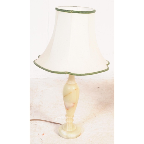 619 - A group of four mid 20th century turned onyx table lamp lights. With light fixings to top, into a ta... 