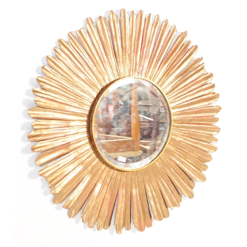 620 - A vintage 20th century metal sunray / sunburst hanging wall mirror. Of circular form with shaped met... 