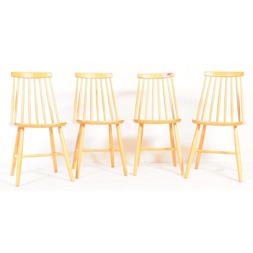 633 - A set of four contemporary Ercol style dining chairs. With single horizontal slat with spindle back ... 
