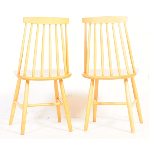 633 - A set of four contemporary Ercol style dining chairs. With single horizontal slat with spindle back ... 