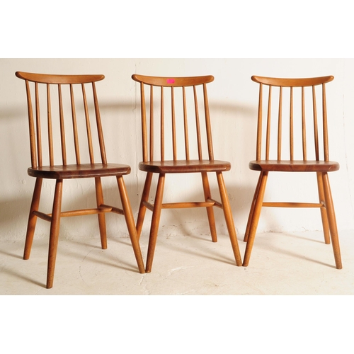 634 - A set of three retro mid 20th century teak spindle back dining chairs. The chair shaving shaped top ... 