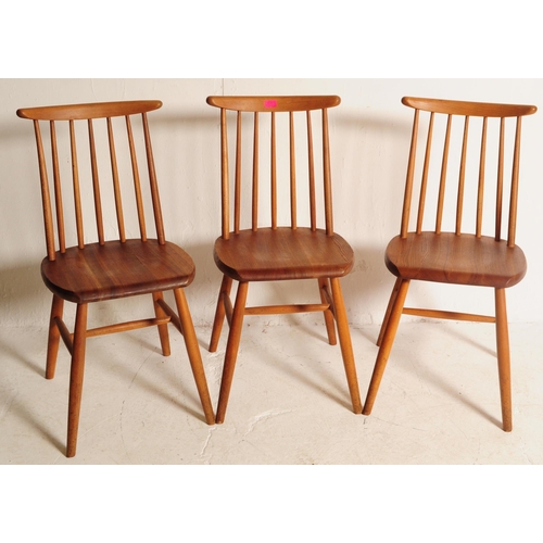 634 - A set of three retro mid 20th century teak spindle back dining chairs. The chair shaving shaped top ... 