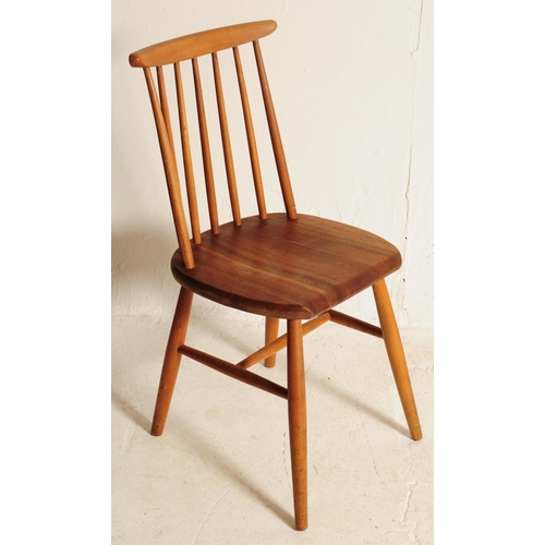 634 - A set of three retro mid 20th century teak spindle back dining chairs. The chair shaving shaped top ... 