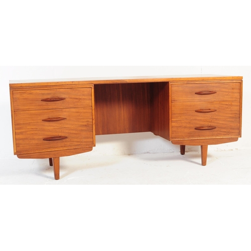 644 - Avalon - A retro mid 20th century teak desk having curvilinear top over kneehole flanked by twin ban... 