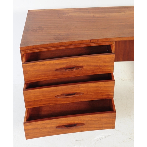 644 - Avalon - A retro mid 20th century teak desk having curvilinear top over kneehole flanked by twin ban... 