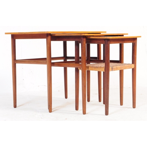 658 - A mid-century Danish manner dark teak wood nest of tables being raised on tapering legs with stretch... 