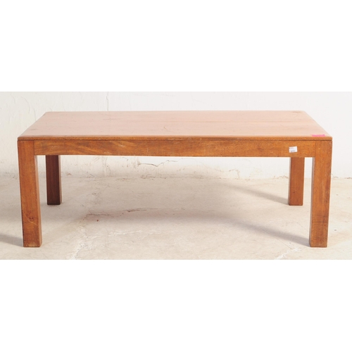 673 - A mid century large teak wood coffee table. Raised on square tapering with fitted frieze under a lar... 