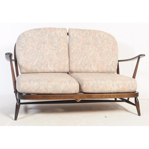 691 - Ercol - Windsor - A mid 20th century beech and elm Ercol sofa. The sofa having shaped top rail over ... 