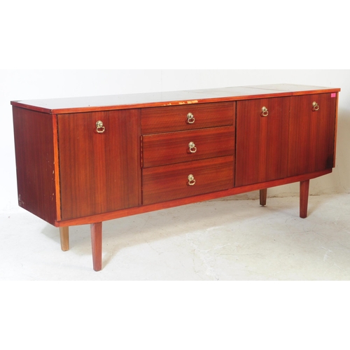723 - A 1960s mahogany wood sideboard credenza. Of rectangular form with a bank of four drawers to offset ... 
