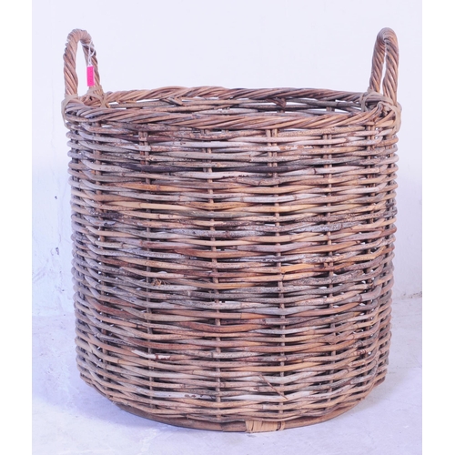 730 - A large mid 20th Century wicker log bin having open top with carry loops. The basket of large size a... 