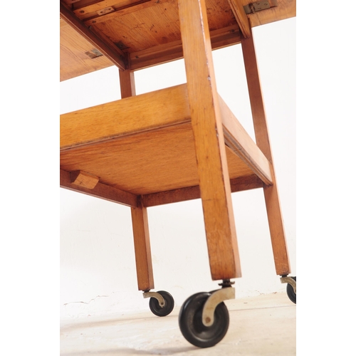 737 - A retro mid 20th century teak serving / butler tray trolley. Rectangular form with drop leaves for e... 