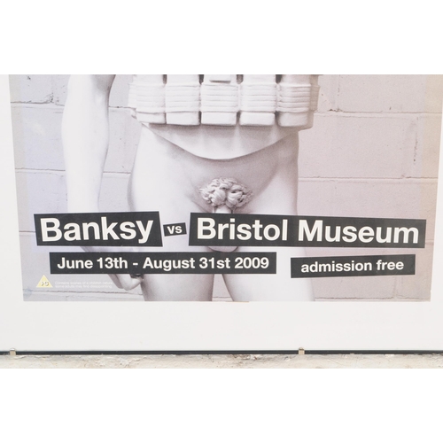 758 - Banksy - A 2009 Banksy vs Bristol Museum exhibition poster featuring photograph of Banksy statue of ... 