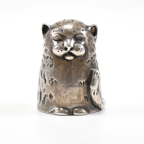 1 - A hallmarked silver novelty thimble in the form of a dozing cat. Hallmarked London 1987. Sponsors ma... 