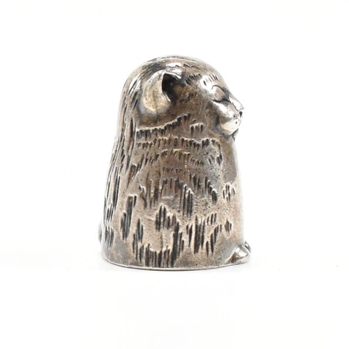 1 - A hallmarked silver novelty thimble in the form of a dozing cat. Hallmarked London 1987. Sponsors ma... 