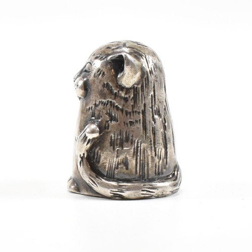 1 - A hallmarked silver novelty thimble in the form of a dozing cat. Hallmarked London 1987. Sponsors ma... 