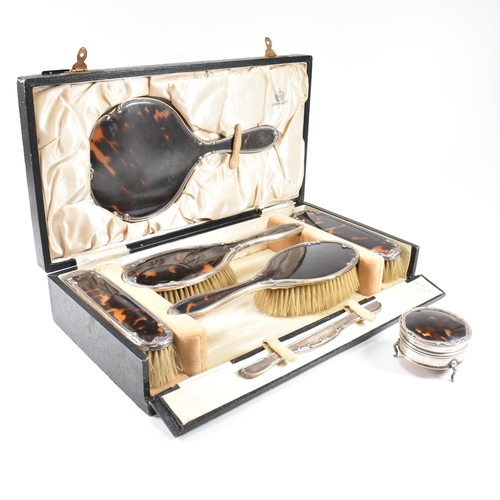 104 - A George V hallmarked silver and tortoiseshell mounted, cased vanity set. The six piece set to inclu... 