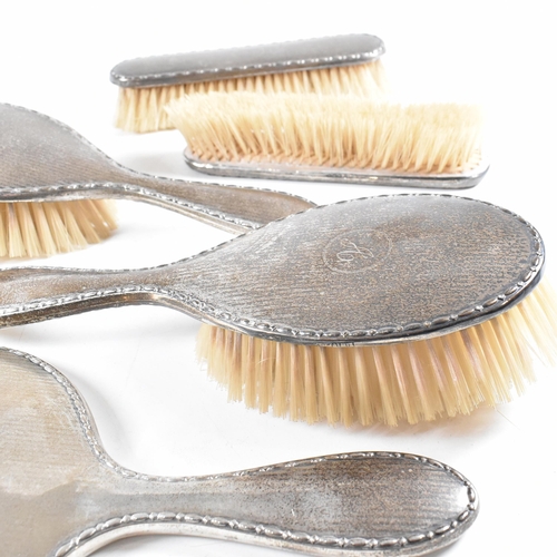 116 - A George V Hallmarked silver mounted five piece vanity set. The set comprised of two hair brushes, t... 