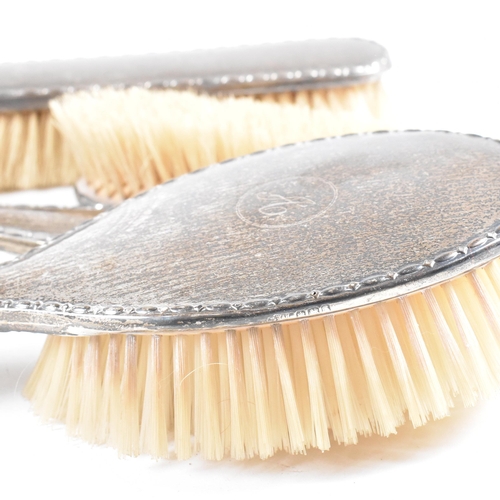 116 - A George V Hallmarked silver mounted five piece vanity set. The set comprised of two hair brushes, t... 