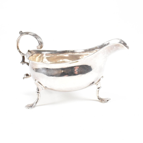 127 - A Georgian hallmarked silver sauce boat. The George III sauce boat having three hoof feet raising to... 