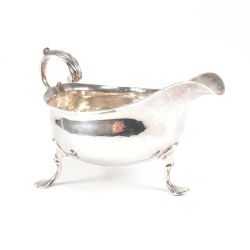 127 - A Georgian hallmarked silver sauce boat. The George III sauce boat having three hoof feet raising to... 