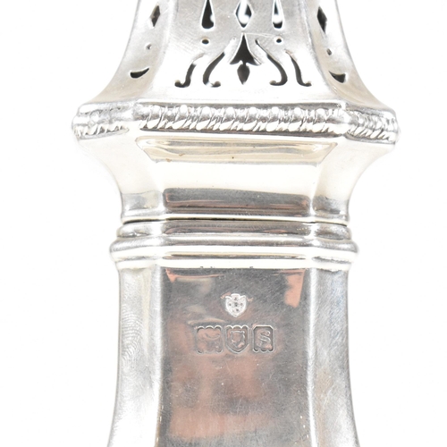 139 - A George V hallmarked silver sugar caster. The caster sitting on a plinth base with repousse decorat... 