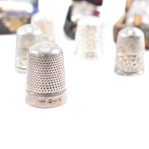 141 - A collection of fifteen hallmarked silver and white metal thimbles with five fitted cases. The lot t... 