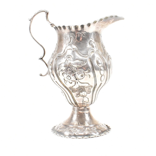 15 - A George III hallmarked silver creamer. The creamer or jug having a circular plinth base rising to a... 