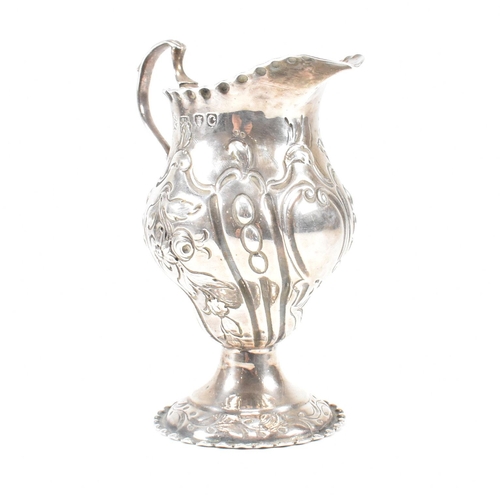 15 - A George III hallmarked silver creamer. The creamer or jug having a circular plinth base rising to a... 