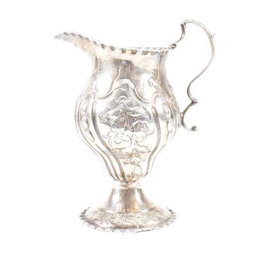 15 - A George III hallmarked silver creamer. The creamer or jug having a circular plinth base rising to a... 