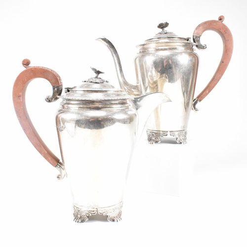 16 - A 1950s hallmarked silver coffee and tea pot set. The pair both standing on four hoof feet with scro... 