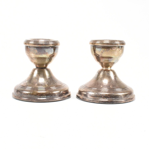 165 - A pair of contemporary hallmarked silver squat candlestick holders. The candlesticks having a weight... 