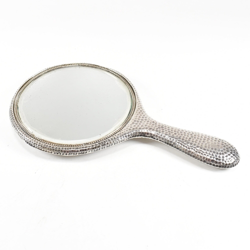 172 - An Edwardian hallmarked silver hand mirror. The mirror having planished decoration with vacant carto... 