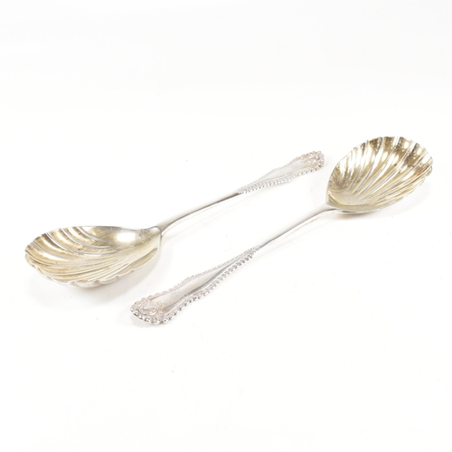 178 - A cased pair of George V hallmarked silver serving spoons.ÿThe spoons having a fluted scallop design... 