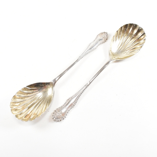 178 - A cased pair of George V hallmarked silver serving spoons.ÿThe spoons having a fluted scallop design... 