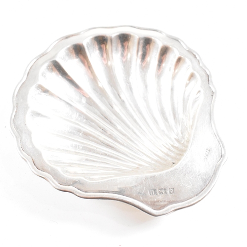 186 - Two hallmarked silver trinket dishes. The lot to include a George V dish in the form of a shell, rai... 