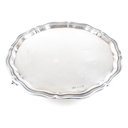 20 - A Mid-century hallmarked silver salver. The salver being raised on three scrolled feet and having a ... 