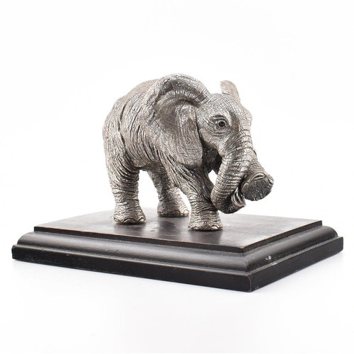 203 - A hallmarked silver Country Artists elephant figurine. The figurine of an Elephant mounted on a hard... 