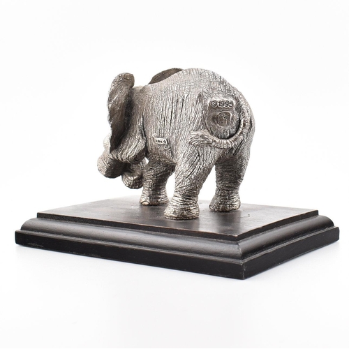 203 - A hallmarked silver Country Artists elephant figurine. The figurine of an Elephant mounted on a hard... 