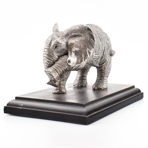 203 - A hallmarked silver Country Artists elephant figurine. The figurine of an Elephant mounted on a hard... 