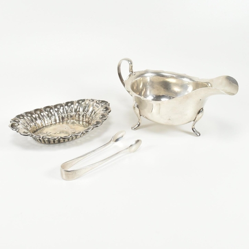 207 - A collection of early to mid century hallmarked silver items. The lot to include a silver sauce boat... 