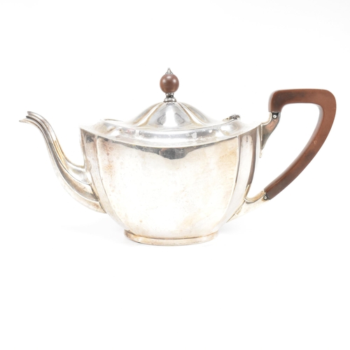 23 - A 1930s hallmarked silver tea pot. The George V tea pot sitting on an oval plinth base raising to a ... 